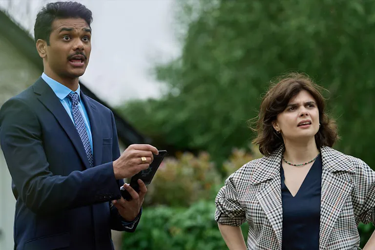 A man and a woman looking to the right of the frame. The man is talking explaining something.