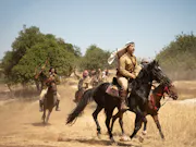 A small group of Palestinian men galloping on horses
