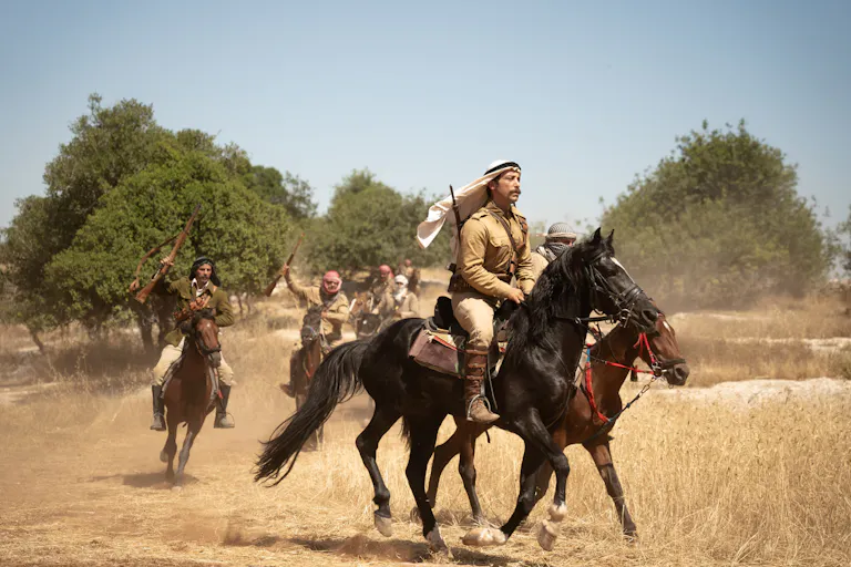 A small group of Palestinian men galloping on horses