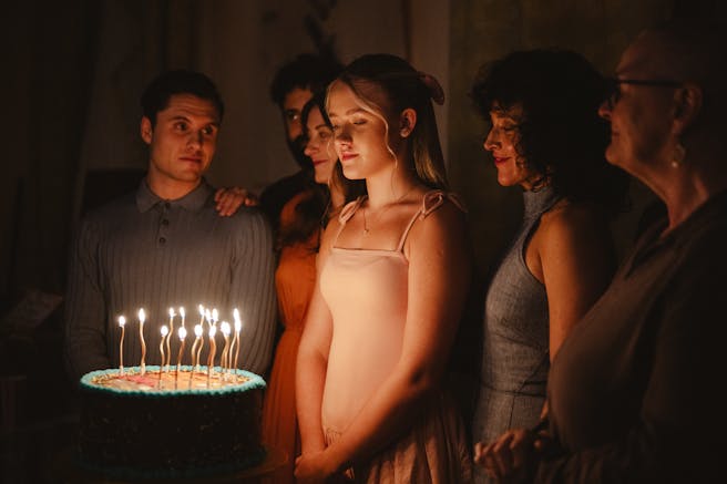 a girl and a cake with lit candles