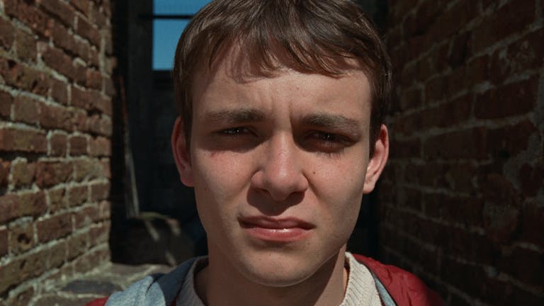 Close up of a young white man with the sun in his eyes