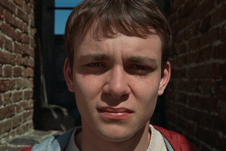 Close up of a young white man with the sun in his eyes