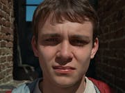 Close up of a young white man with the sun in his eyes