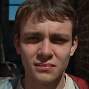 Close up of a young white man with the sun in his eyes