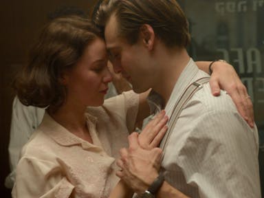 A young white woman and man in 1930s clothing, dancing closely and tenderly with their heads resting against each other