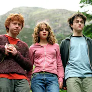 A ginger white teen boy holding a rat stands next to a white teen girl and a white teen boy wearing glasses with a scar on his forehead