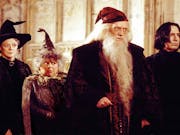 Four wizards with capes and hats looking towards the right of the screen