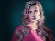 A distorted image of a blonde woman facing the camera