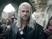 A white man with long white hair and hazel eyes, wearing black leather and a sword strapped to his back