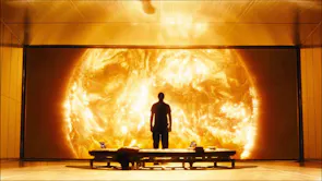A full-body shot of a person standing in front of a window looking at a dangerously close sun