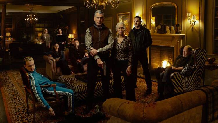 A white family stands around a fireplace looking ominously at the camera.