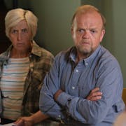 A middle aged white woman and man looking concerned and upset