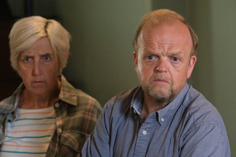 A middle aged white woman and man looking concerned and upset