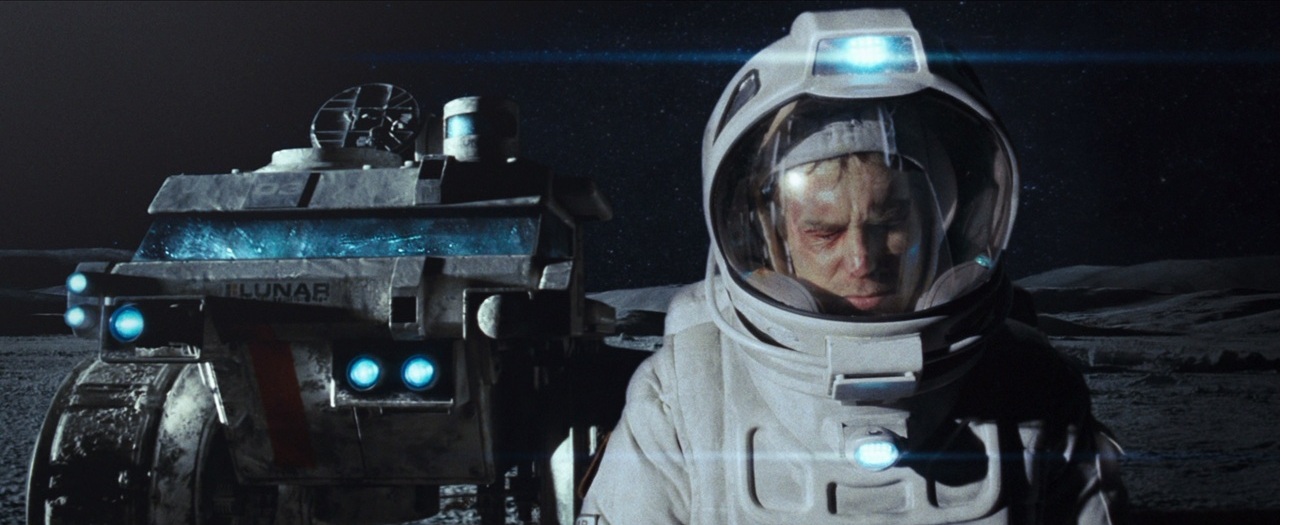 A man wearing a spacesuit on the moon, walking beside a large space drone