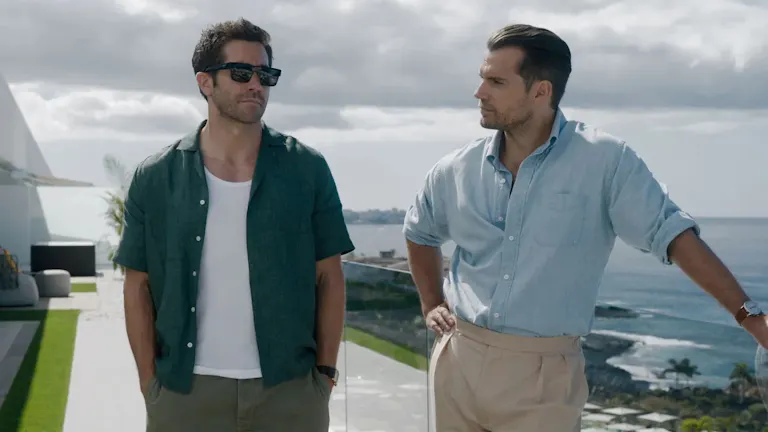 Two men standing on the balcony of a beach house