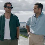 Two men standing on the balcony of a beach house