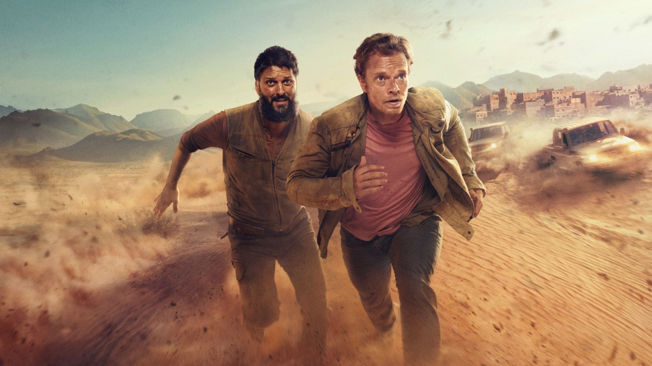 Two white men in the desert running aggressively away from cars