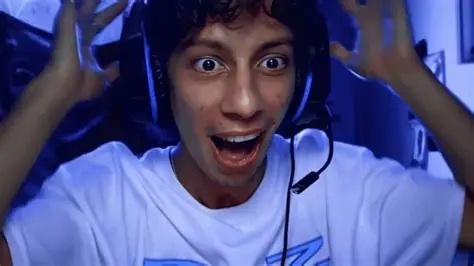 A South Asian young boy wearing a gaming headset, with a shocked look on his face and his hands on his head
