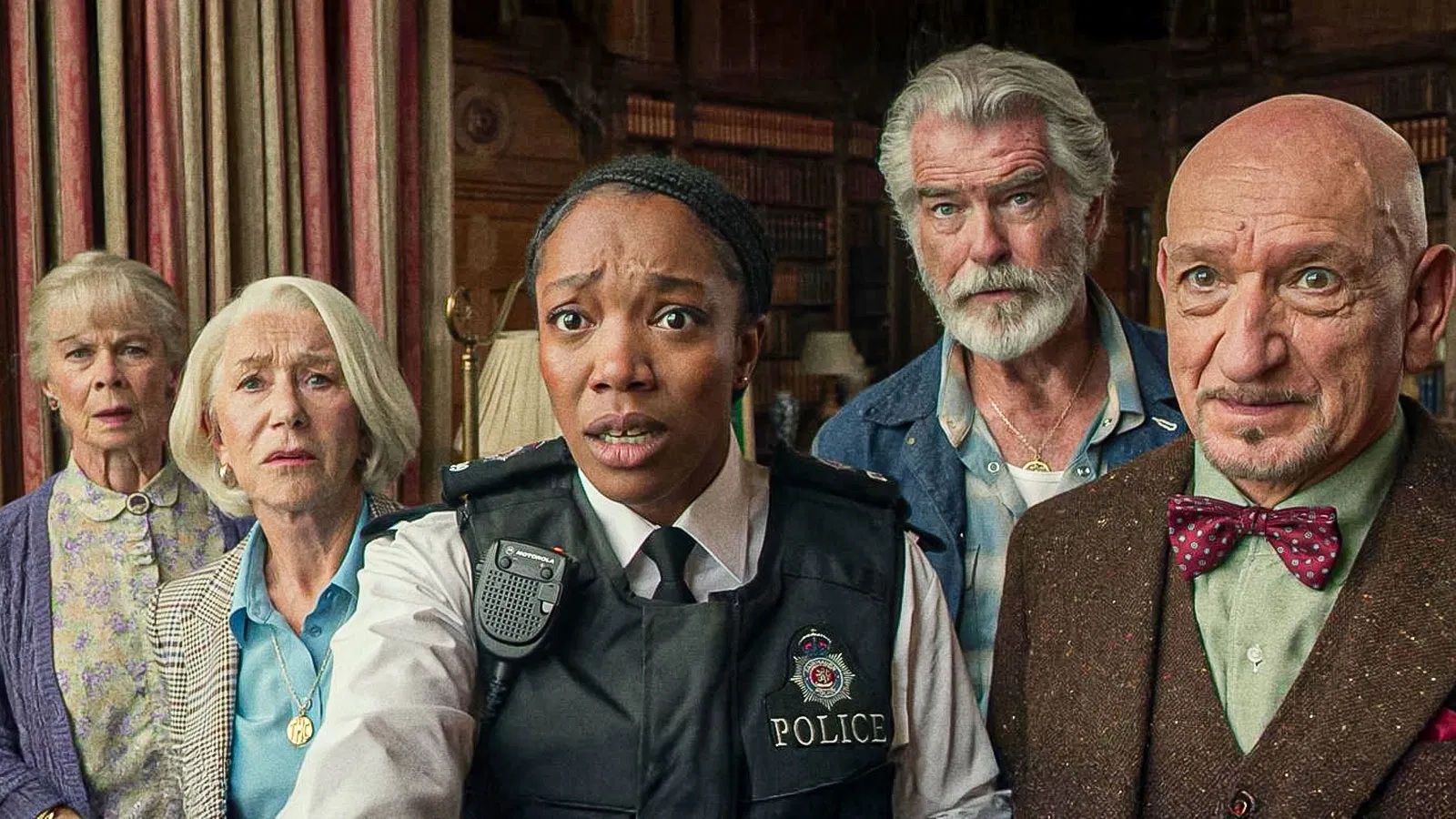A black police officer with cornrowed hair standing in the middle of 4 older people (two white women, a white man and a south asian man), all with conflicting facial expressions: shocked, intruiged, enlightened and confused