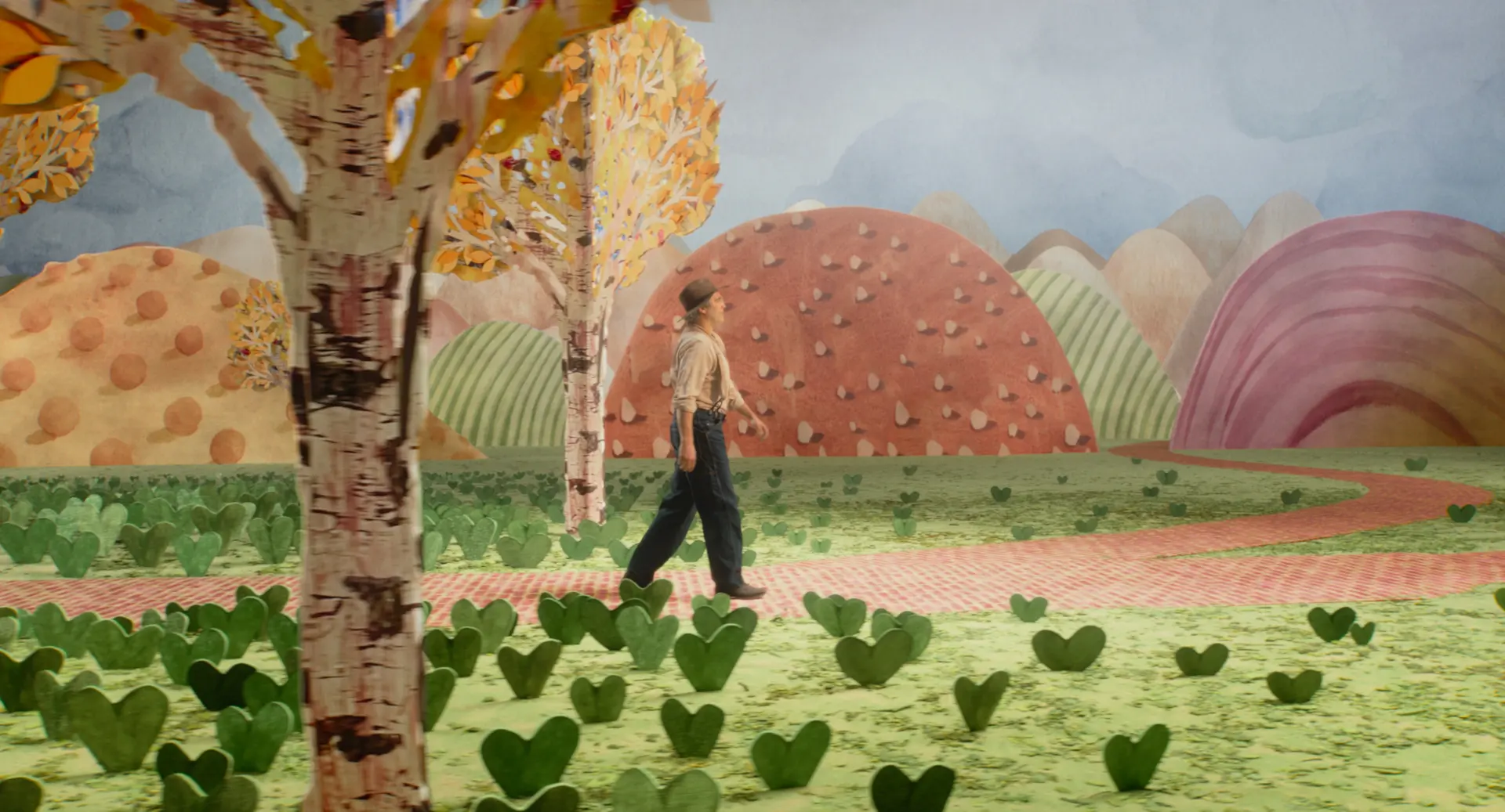 A middle-aged man in farmer-like clothes wandering through a colourful park made of arts and crafts