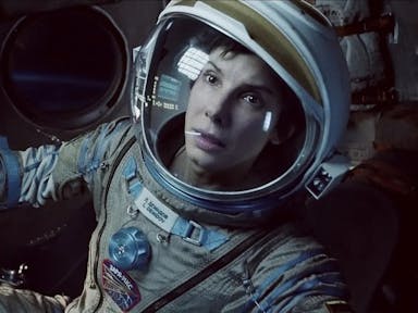 Close up of a white woman in an astronaut suit looking serious