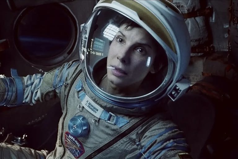 Close up of a white woman in an astronaut suit looking serious