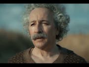 An older white man with big curly white hair and a thick grey moustache looking forlorn