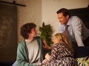 Two parents look lovingly at their teenage son