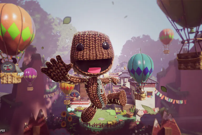 Animated video game image of a knitted creature flying through the air, smiling, with hot air balloons all around him in the sky.