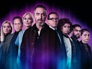 A group of serious looking people staring at the camera with a purple glow around them