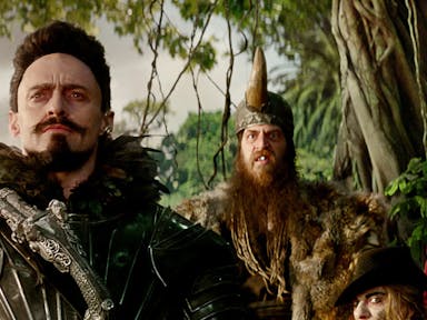 Four white men in fantasy pirate style looking menacing clothing in a jungle 