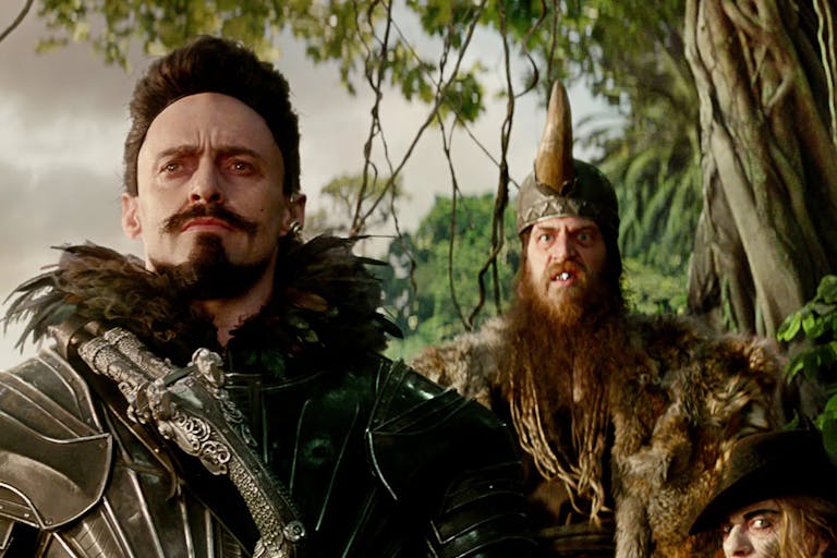 Four white men in fantasy pirate style looking menacing clothing in a jungle 