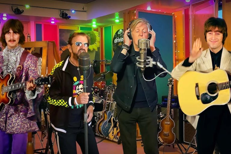 A colour recording studio with four white men, two real life older men (Ringo and Paul McCartney) flanked by digital young men with guitars (George Harrison, and John Lennon)