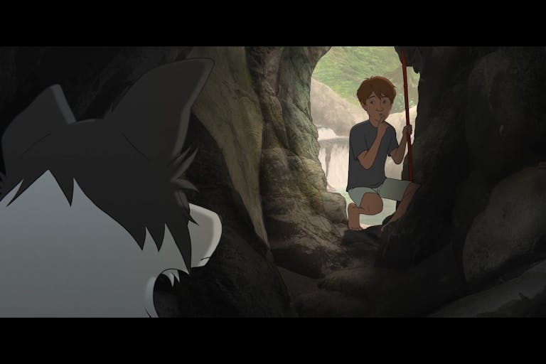 A young white boy at a cave mouth with a bright scene behind him, motions his dog to be quiet