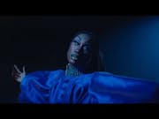 A young Black drag queen in a flouncy deep blue dress dancing, looking ethereal