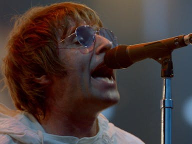 Man in sunglasses sings into a microphone.