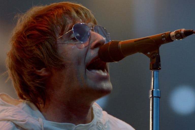 Man in sunglasses sings into a microphone.