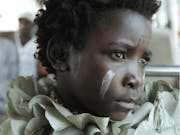 Young girl with white paint marks in her face.