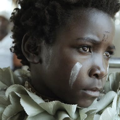 Young girl with white paint marks in her face. 