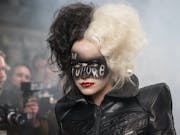 Woman wearing a leather jacket, half of her dyed white and the other half dyed black, has the words 'The Future' written in facepaint across her eyes.