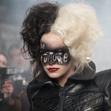 Woman wearing a leather jacket, half of her dyed white and the other half dyed black, has  the words 'The Future' written in facepaint across her eyes. 