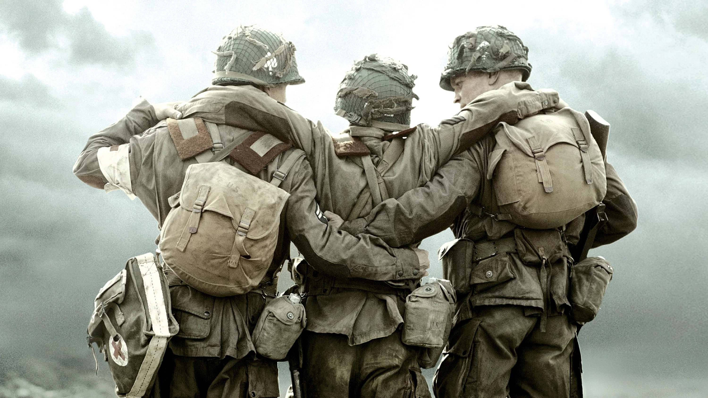 Three army soldiers in their gear. The two on either end holding the middle guy up