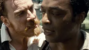 An angry-faced white man shouting in the face of a black man