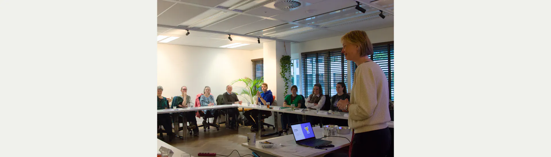 Kim van Dijk, Chief Operating Officer of Scribit.Pro, stands before a room filled with pros and experts by experience.