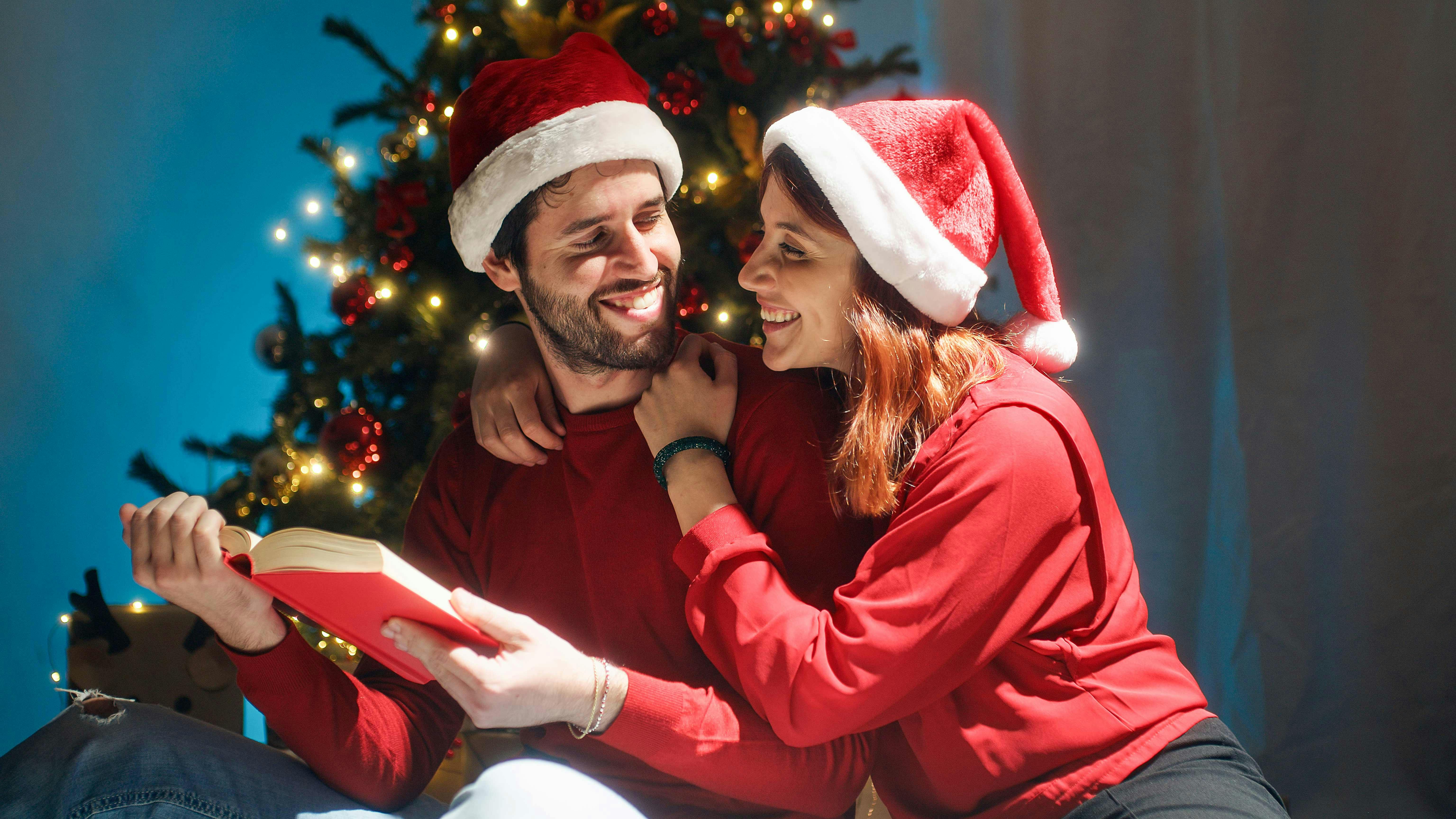 Man and woman reading a book on Christmas Eve.