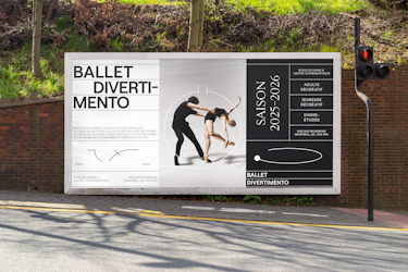 A large outdoor advertising display for Ballet Divertimento installed along a street, set against a brick wall and a traffic light. The billboard features the text “BALLET DIVERTI MENTO” arranged across multiple lines, a central photograph showing two dancers in motion, surrounded by circular graphic elements inspired by Benesh notation. On the right, a vertical column displays “SAISON 2025 2026,” “ÉCOLE DE DANSE ET CENTRE CHORÉGRAPHIQUE,” “ADULTE RÉCRÉATIF,” “JEUNESSE RÉCRÉATIF,” “DANSE ÉTUDES,” and the address “1435 RUE DRUMMOND, MONTRÉAL, QC H3G 1W4.” At the bottom of the panel, the text “BALLET DIVERTIMENTO” is visible. A paragraph on the left explains that Ballet Divertimento offers a stimulating environment in the heart of Montréal where young people can discover dance, develop their abilities, and grow alongside passionate teachers and guest artists.