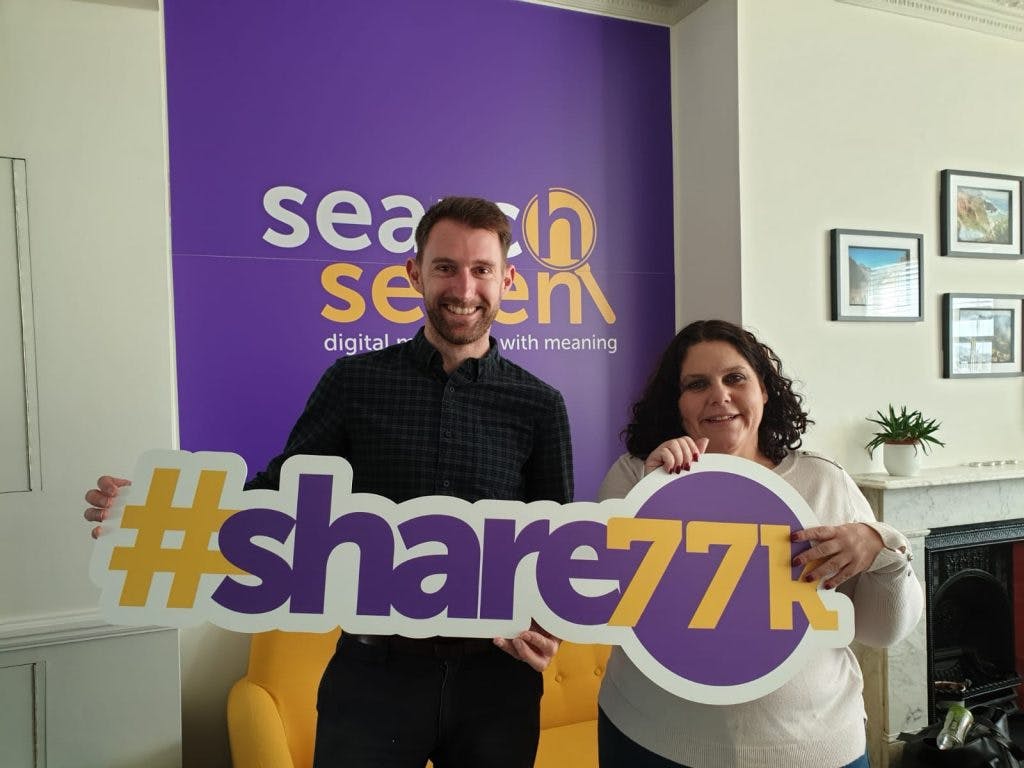 Terrina and Gavin standing with #share77k sign