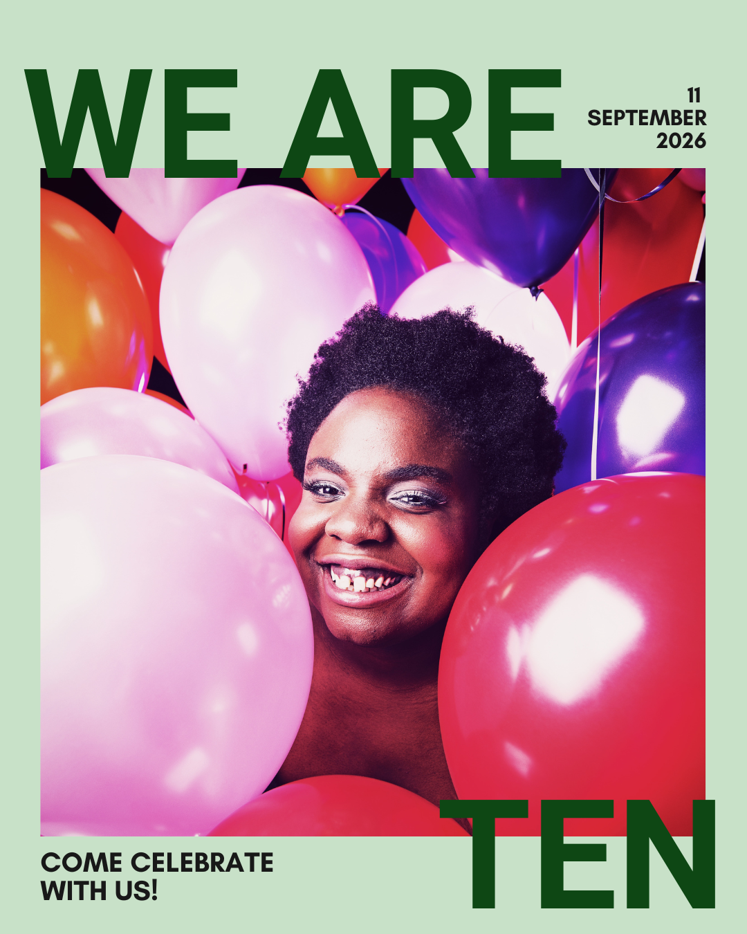 Selina face is smiling at the camera and she is completely surrounded by balloons in tones of pink, purple and reds. 