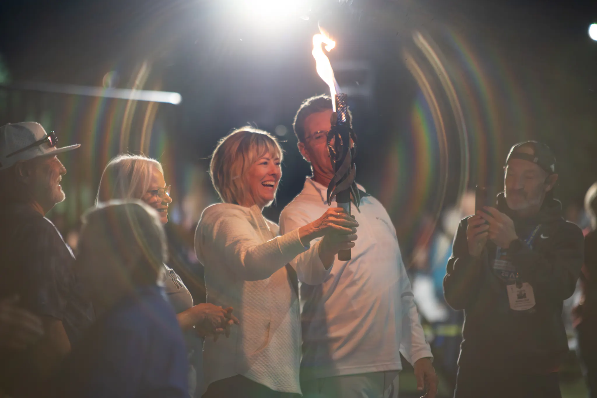 Two athletes pass the Huntsman World Senior Games torch