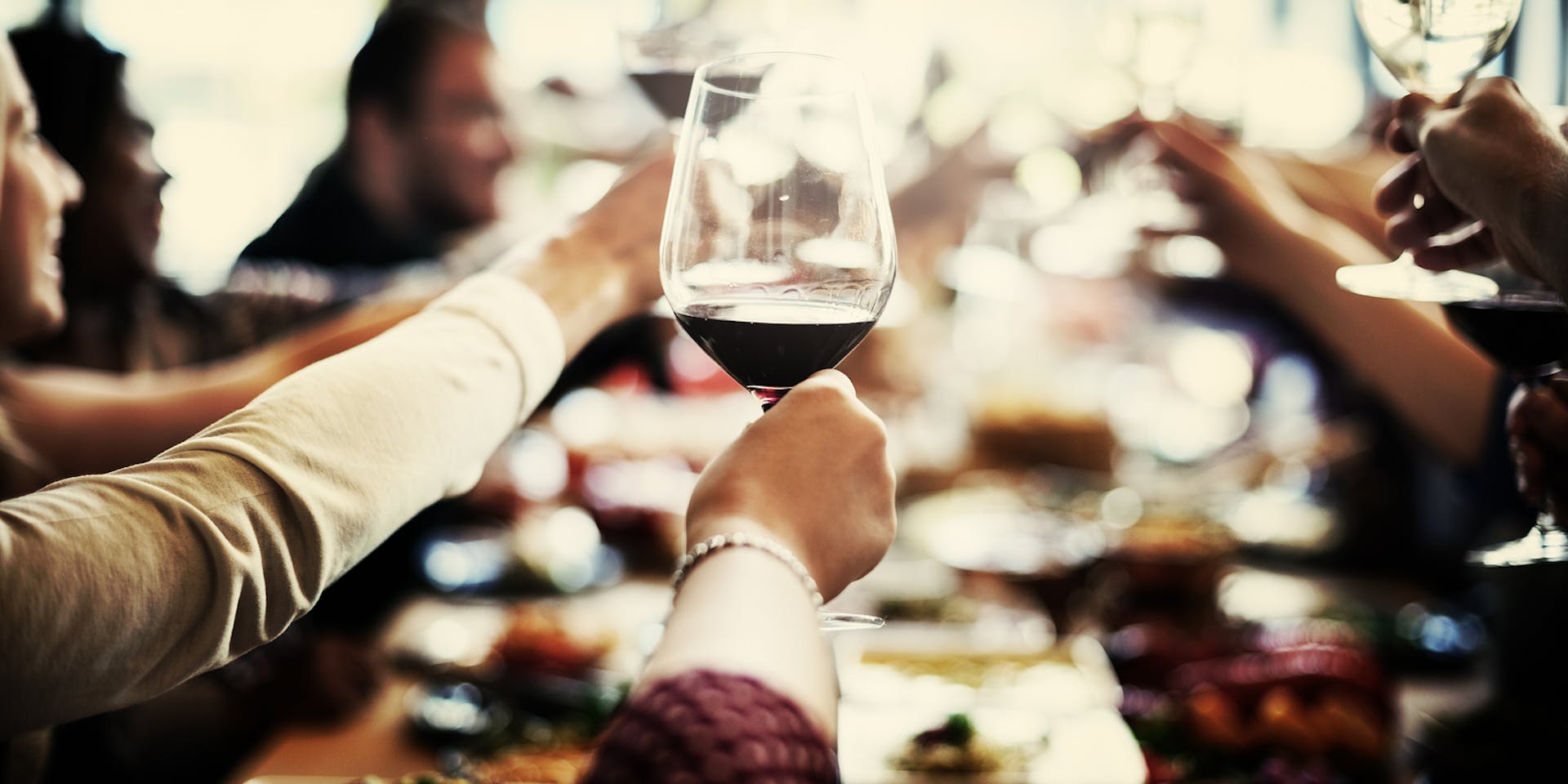 Wine glass raised in a toast.